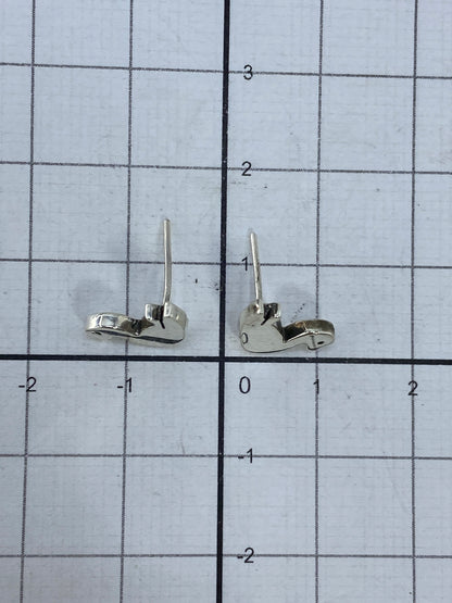 Aretes en la mano mostrando su tamaño diminuto de 1.3 cm