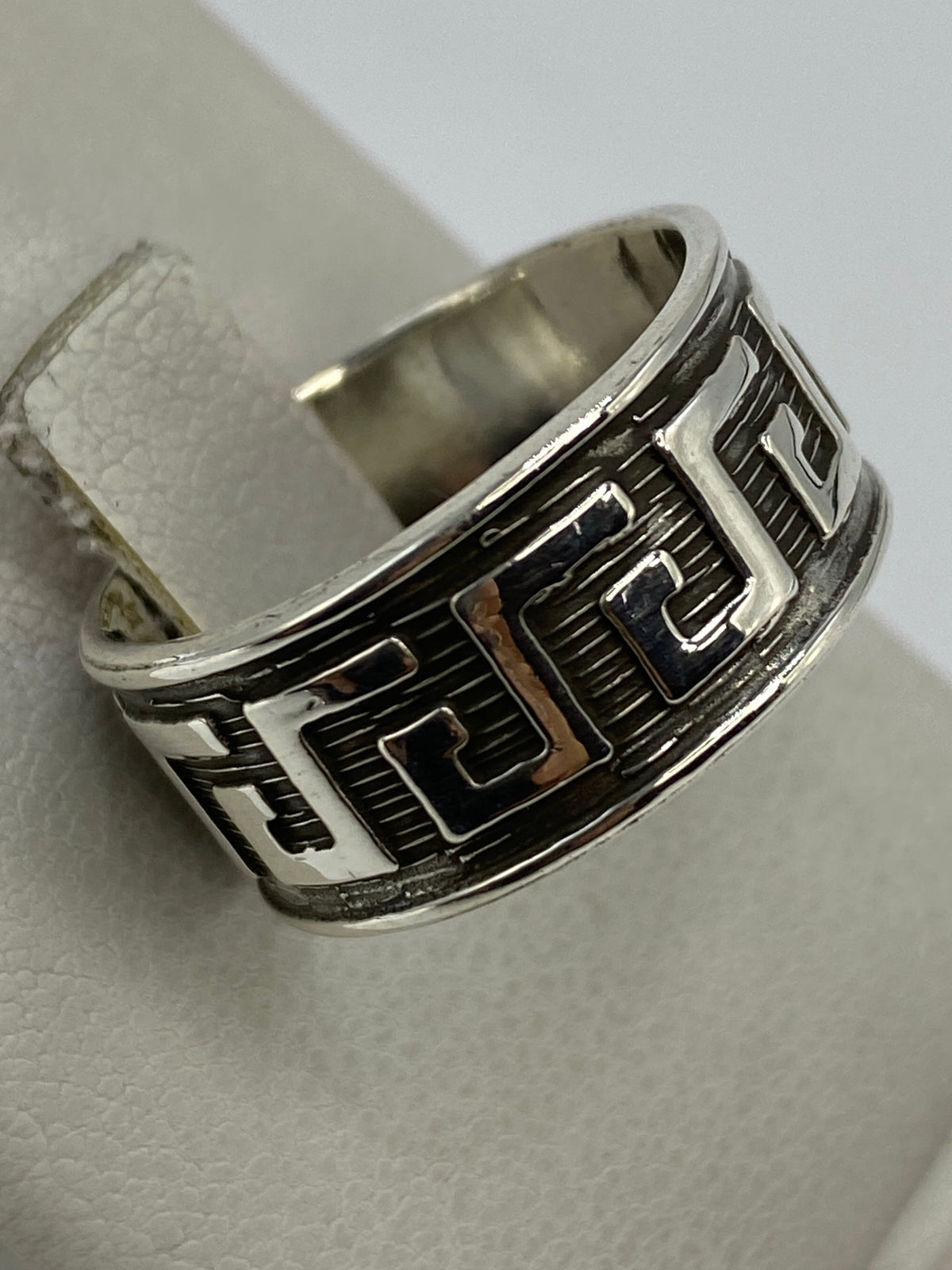 Vista frontal del anillo prehispánico de plata brillante sobre fondo blanco