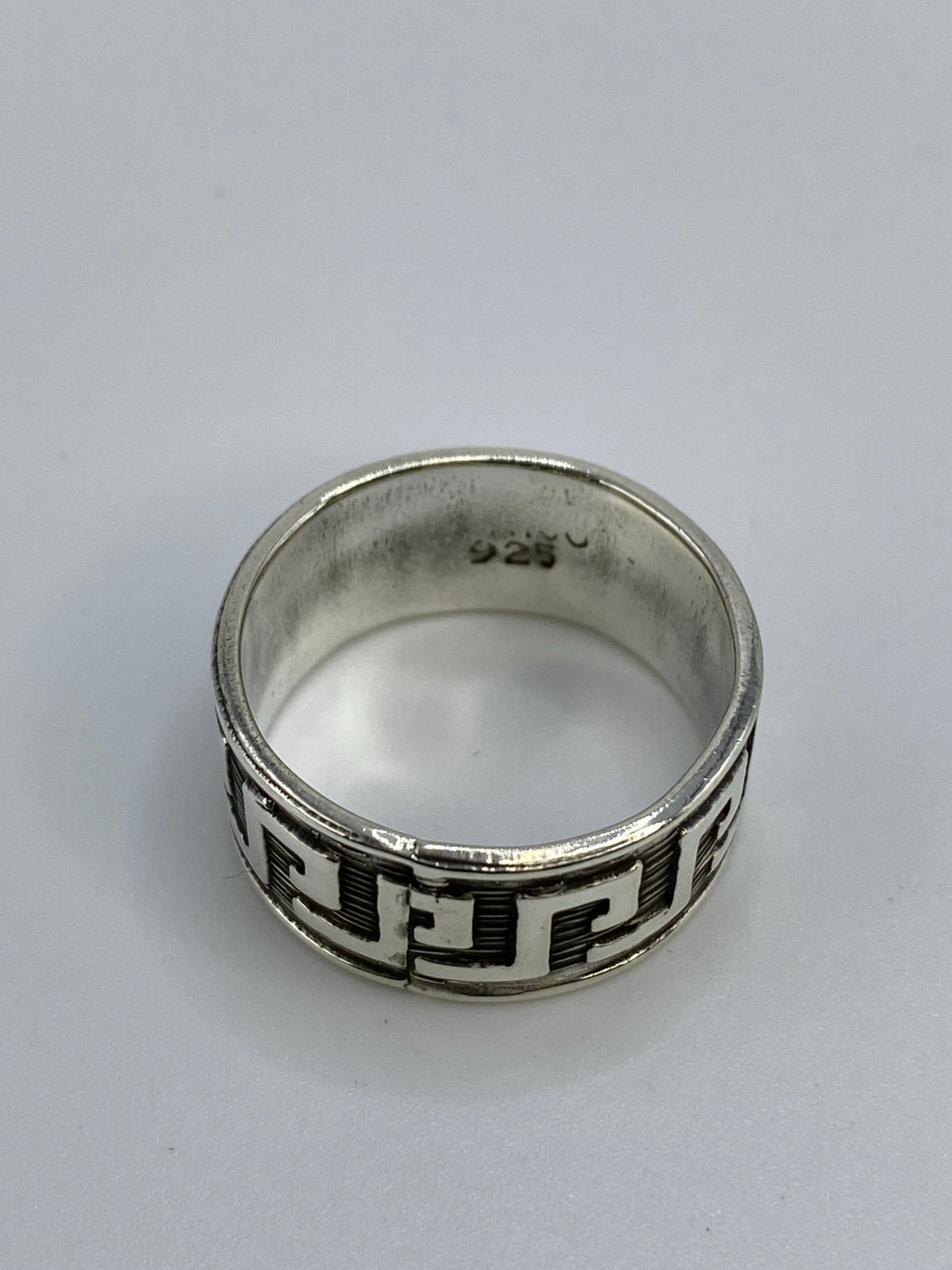 Anillo en la mano mostrando el diseño geométrico y el acabado artesanal