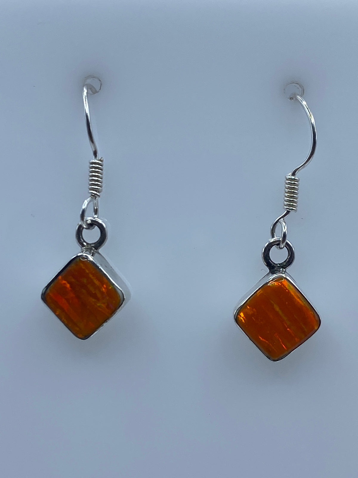 Detalle del Ópalo de Fuego naranja engastado en plata, mostrando el juego de luces