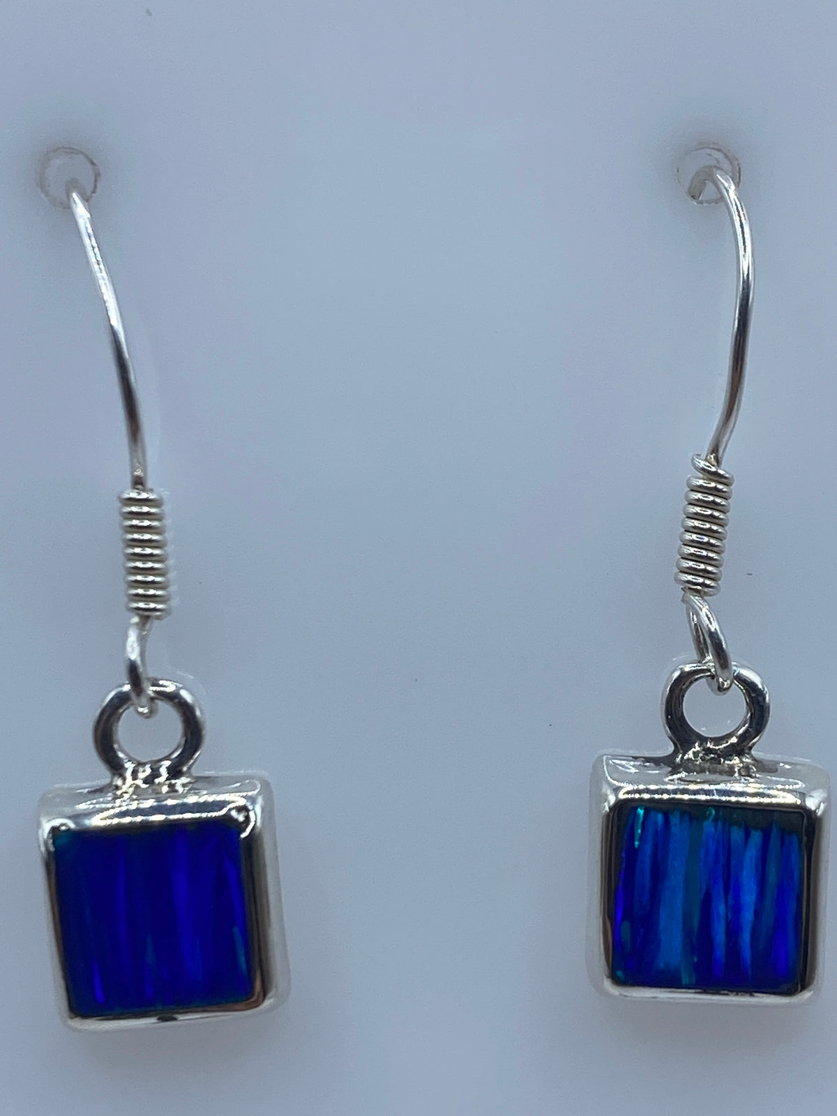Aretes puestos en las orejas, demostrando el largo de 2.6 cm