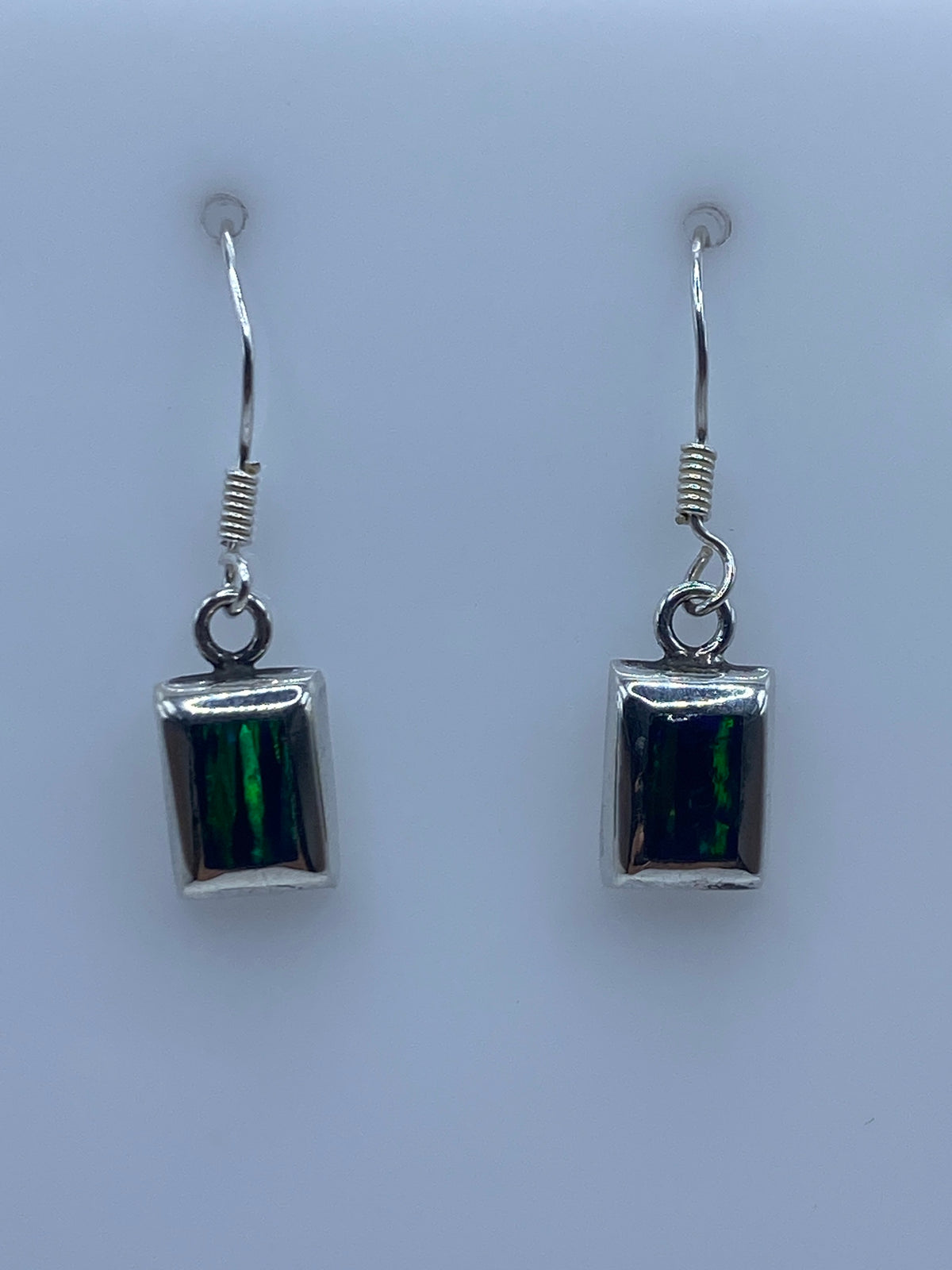 Close-up of fire opal stone showing green and black iridescence in silver setting