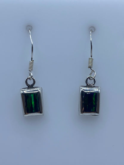 Close-up of fire opal stone showing green and black iridescence in silver setting