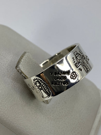Anillo prehispánico sobre fondo azul, luz natural iluminando los relieves