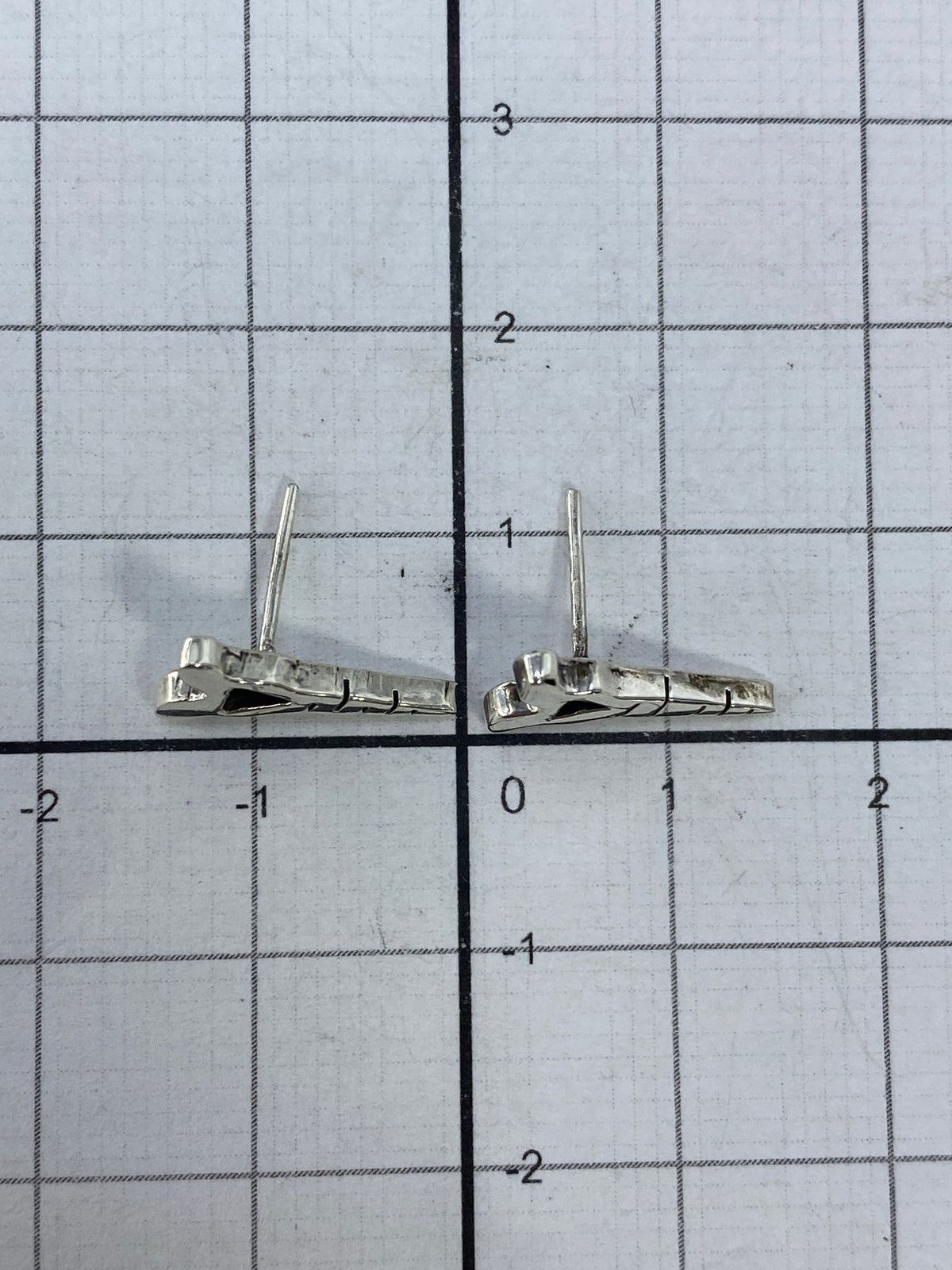 Aretes puestos en oreja, demostrando el tamaño delicado de 1.1 cm