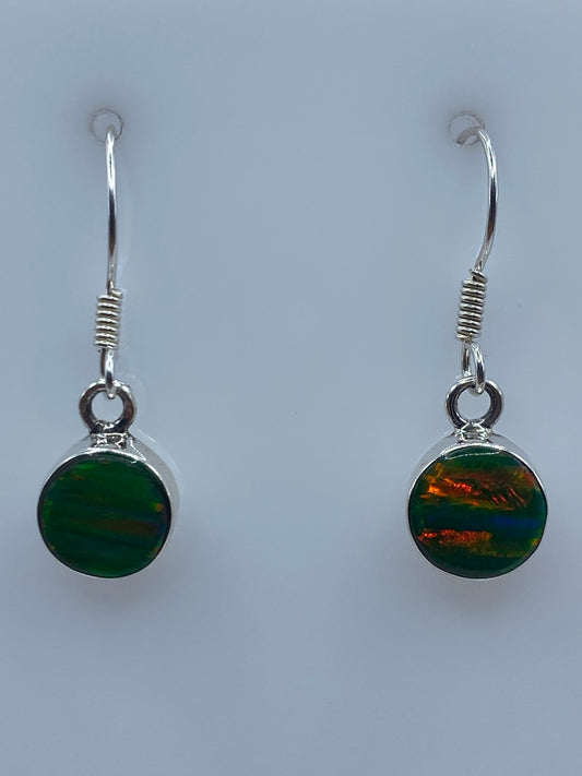 Par de aretes de plata con ópalo de fuego verde limón colgando, vista frontal