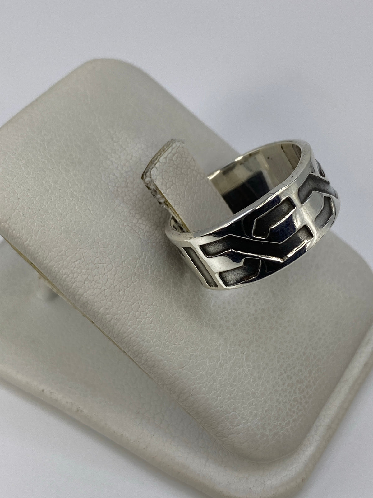Detalle lateral del anillo mostrando los eslabones en relieve y el acabado satinado