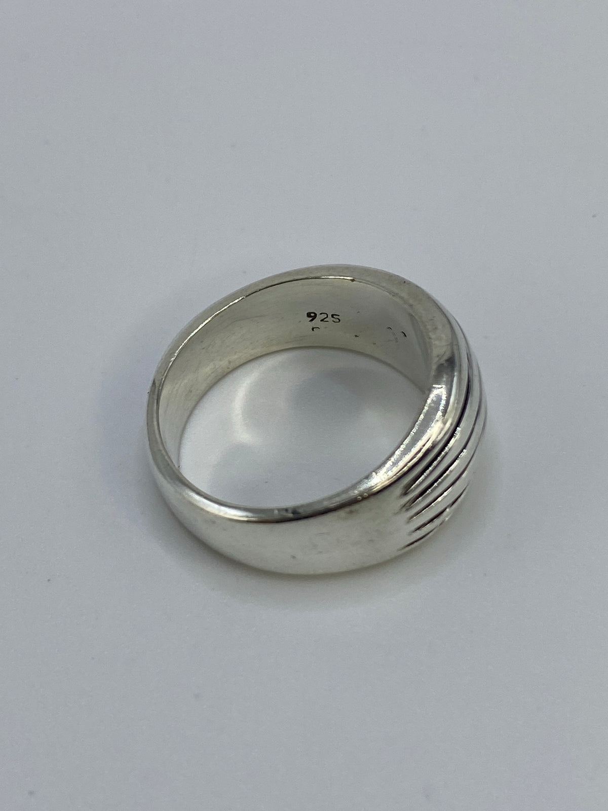 Anillo sobre fondo azul en báscula mostrando 8.1 gramos de plata auténtica