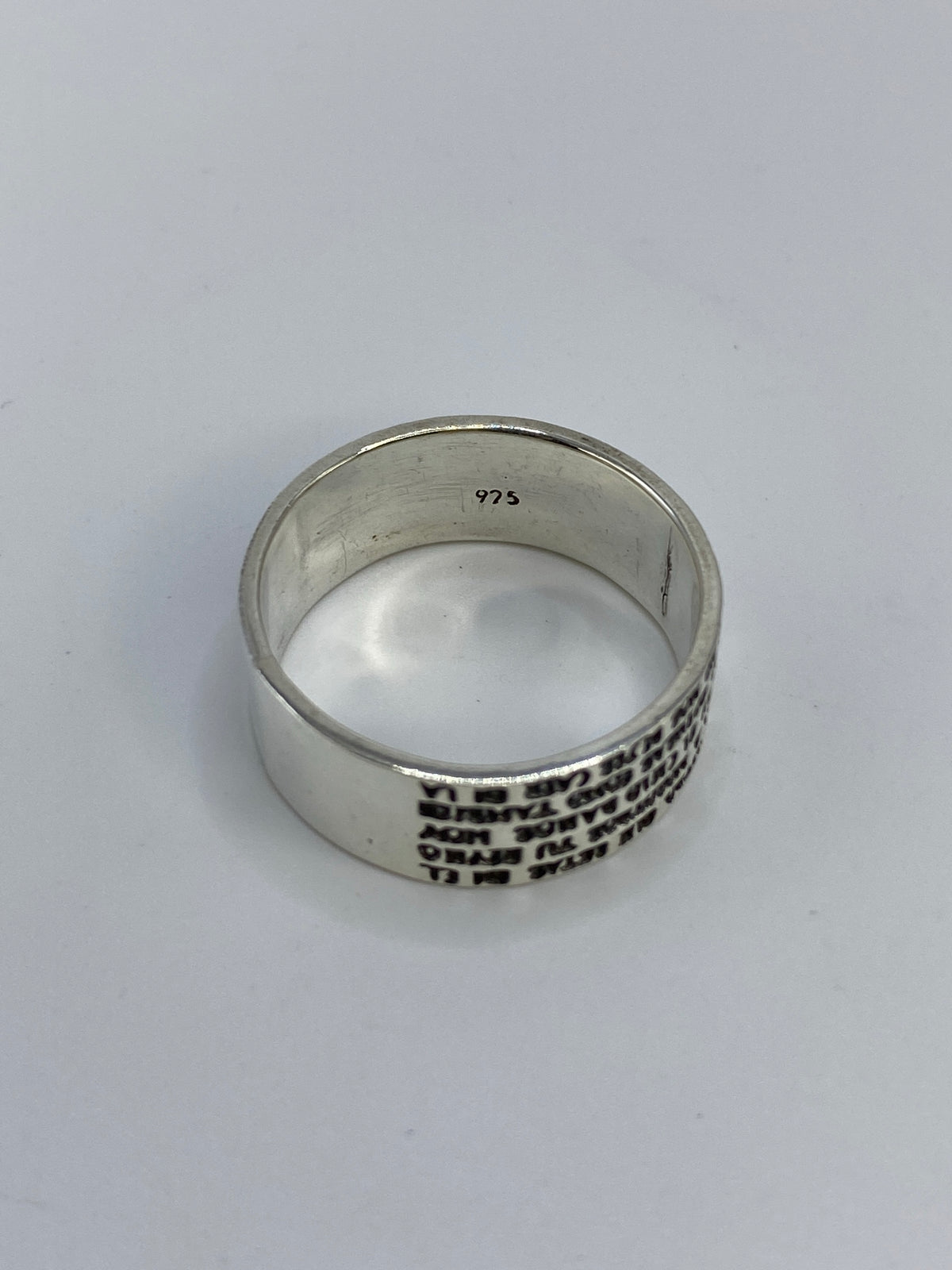 Anillo sobre fondo azul mostrando el acabado pulido de la plata de Taxco