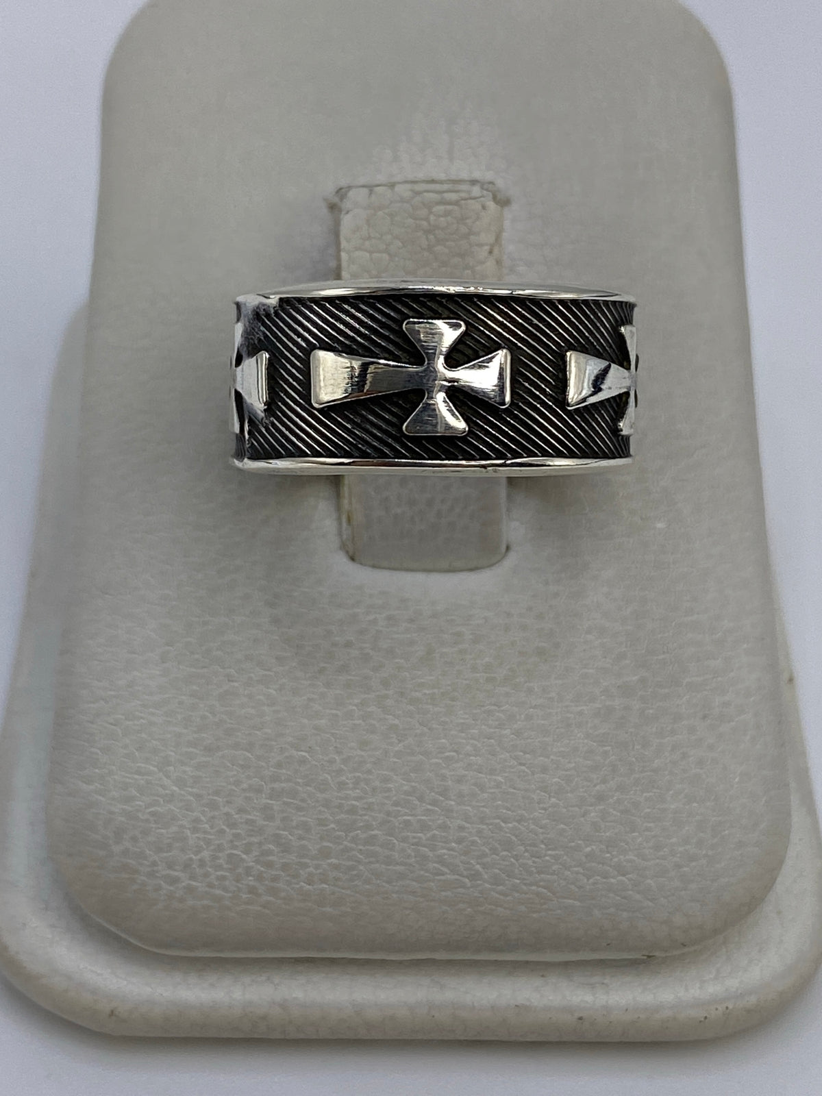 Anillo de plata 925 con cruces religiosas en relieve repujado, sobre fondo neutro