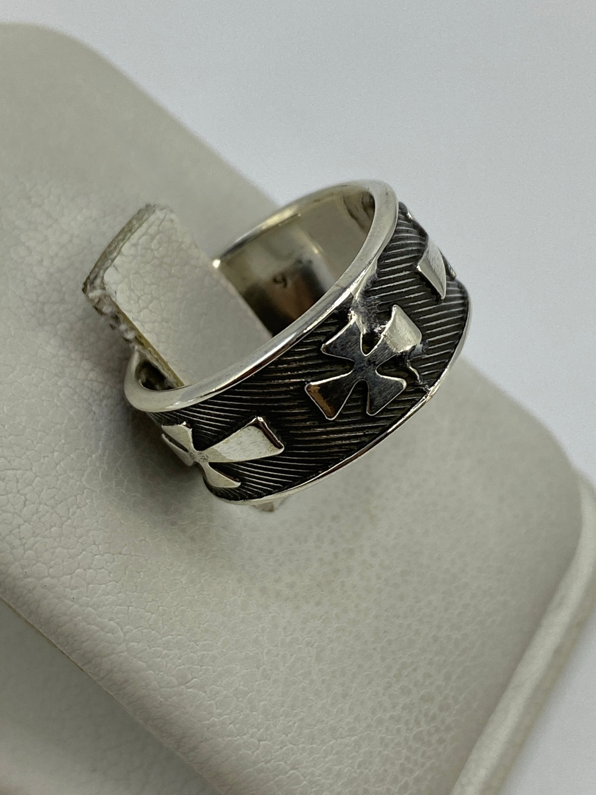 Anillo puesto en dedo, diseño religioso en relieve visible
