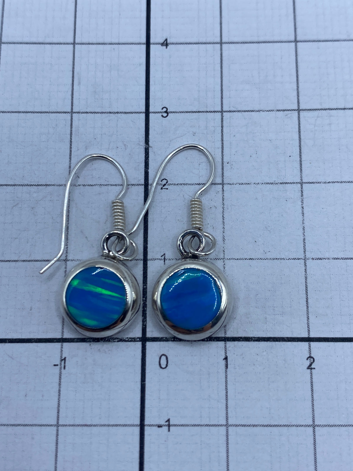 Aretes sobre fondo blanco mostrando la marca del Quinto 950