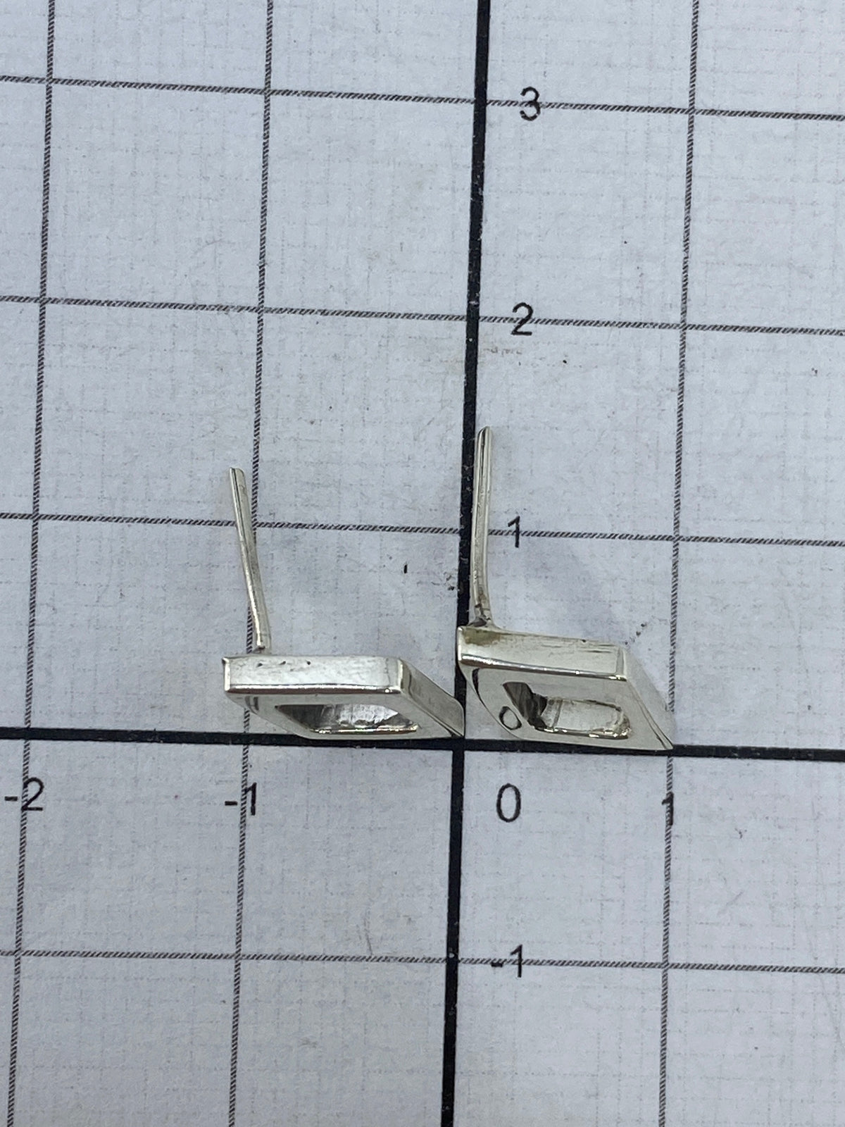 Aretes minimalistas de cartoneado sobre fondo blanco, ligeros y versátiles