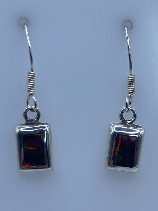 Par de aretes de plata 925 con Ópalo de Fuego multicolor, colgando sobre fondo azul