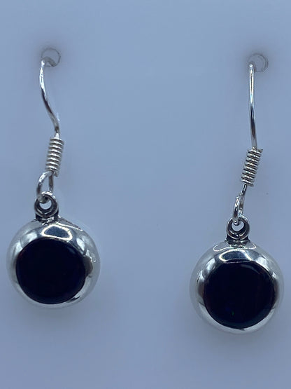Aretes en la mano mostrando el tamaño delicado de 2.7 cm y el Quinto 925