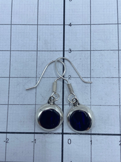 Aretes sobre fondo blanco con gancho de plata visible