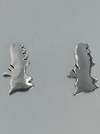 Aretes minimalistas sobre fondo gris claro mostrando el acabado pulido
