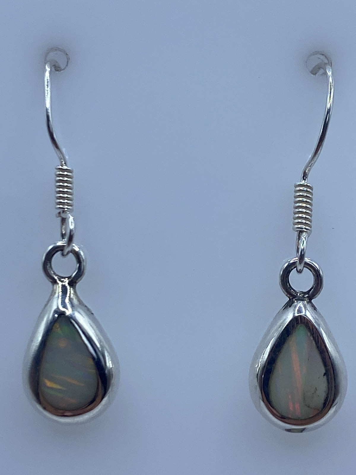 Ambos aretes sobre fondo blanco con gancho de plata visible, midiendo 2.8 cm