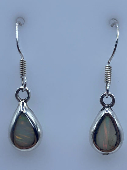 Ambos aretes sobre fondo blanco con gancho de plata visible, midiendo 2.8 cm