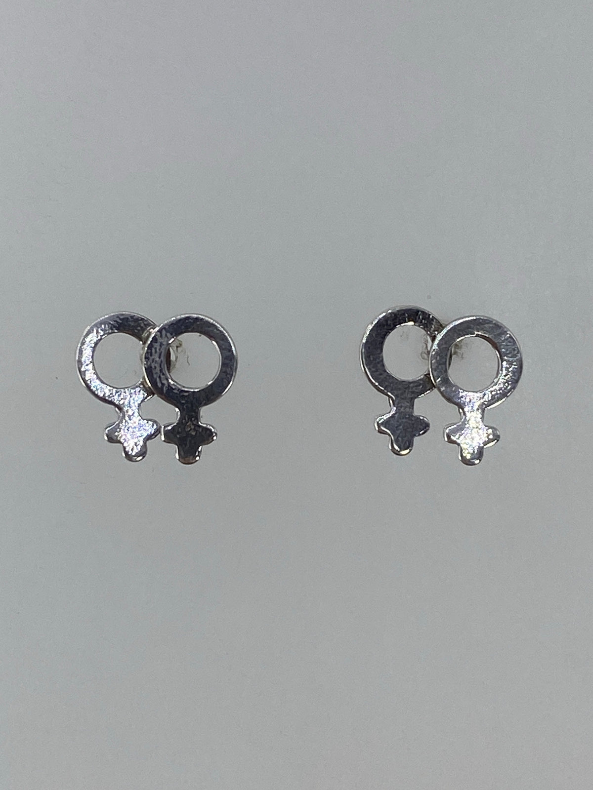 Par de aretes de plata 925 con símbolo femenino en cartoneado, vista frontal