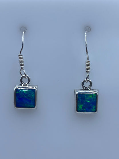 Detalle de uno de los aretes mostrando el engaste a mano y el ópalo azul