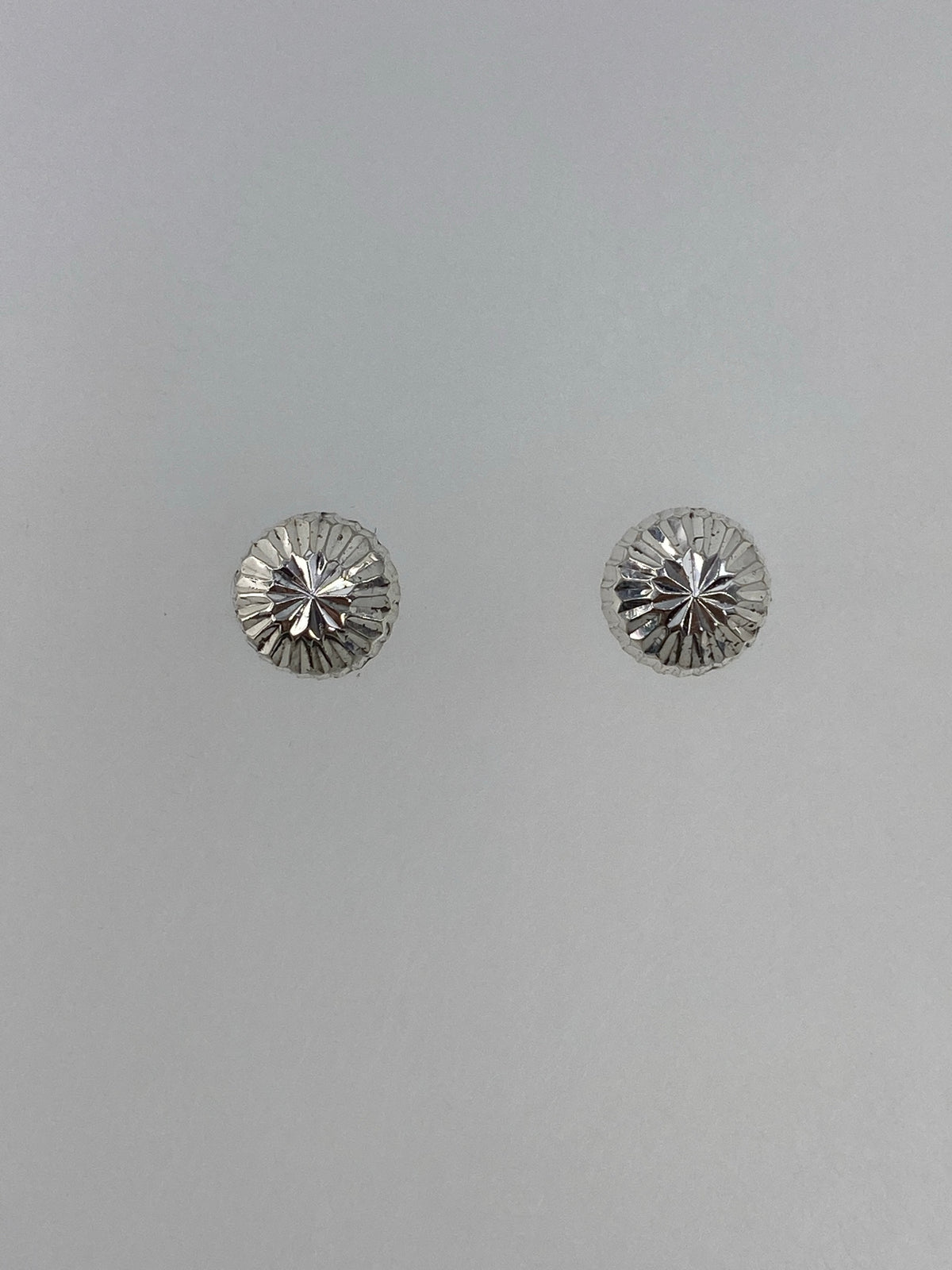 Vista frontal de los aretes cartoneados con volumen 3D y acabado pulido