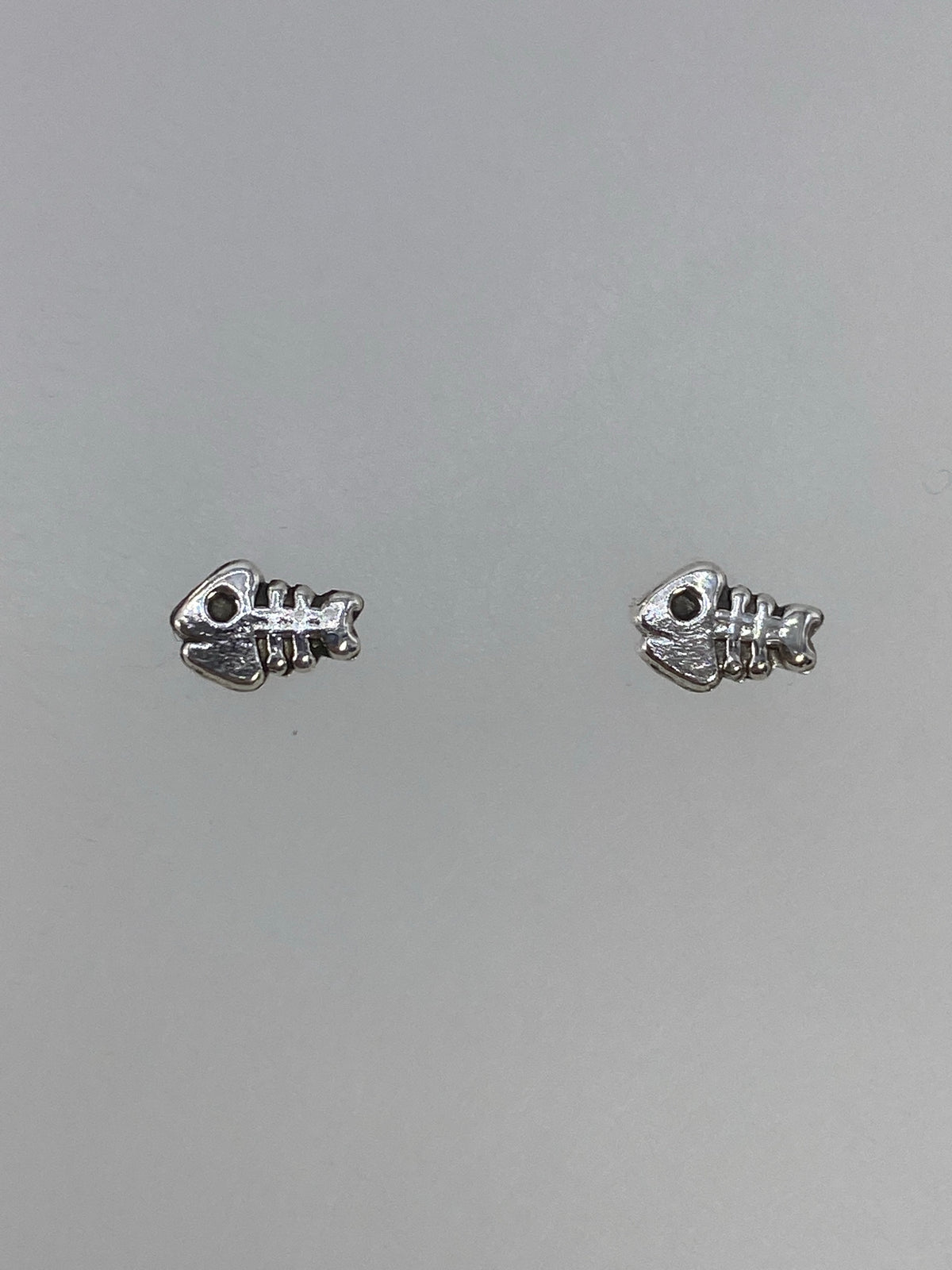 Par de aretes de plata cartoneado minimalistas de 1 cm, colocados sobre medidor de escala