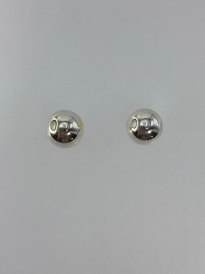 Detalle de los aretes con luz reflejada en el cartoneado de plata