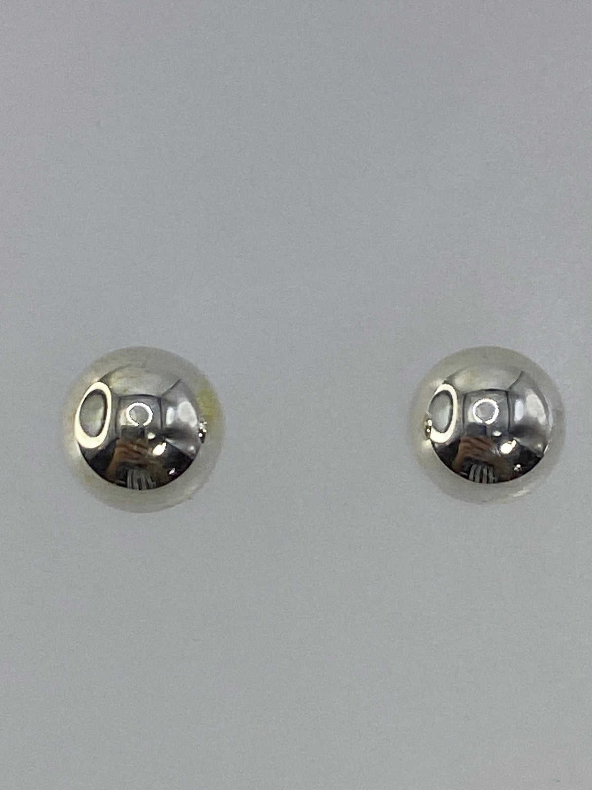 Aretes sobre escala mostrando el peso de 0.9 gramos el par