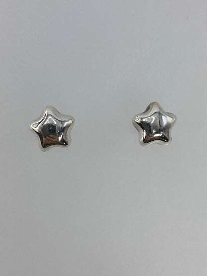 Par de aretes de plata cartoneado en forma de estrella, vista frontal del volumen 3D