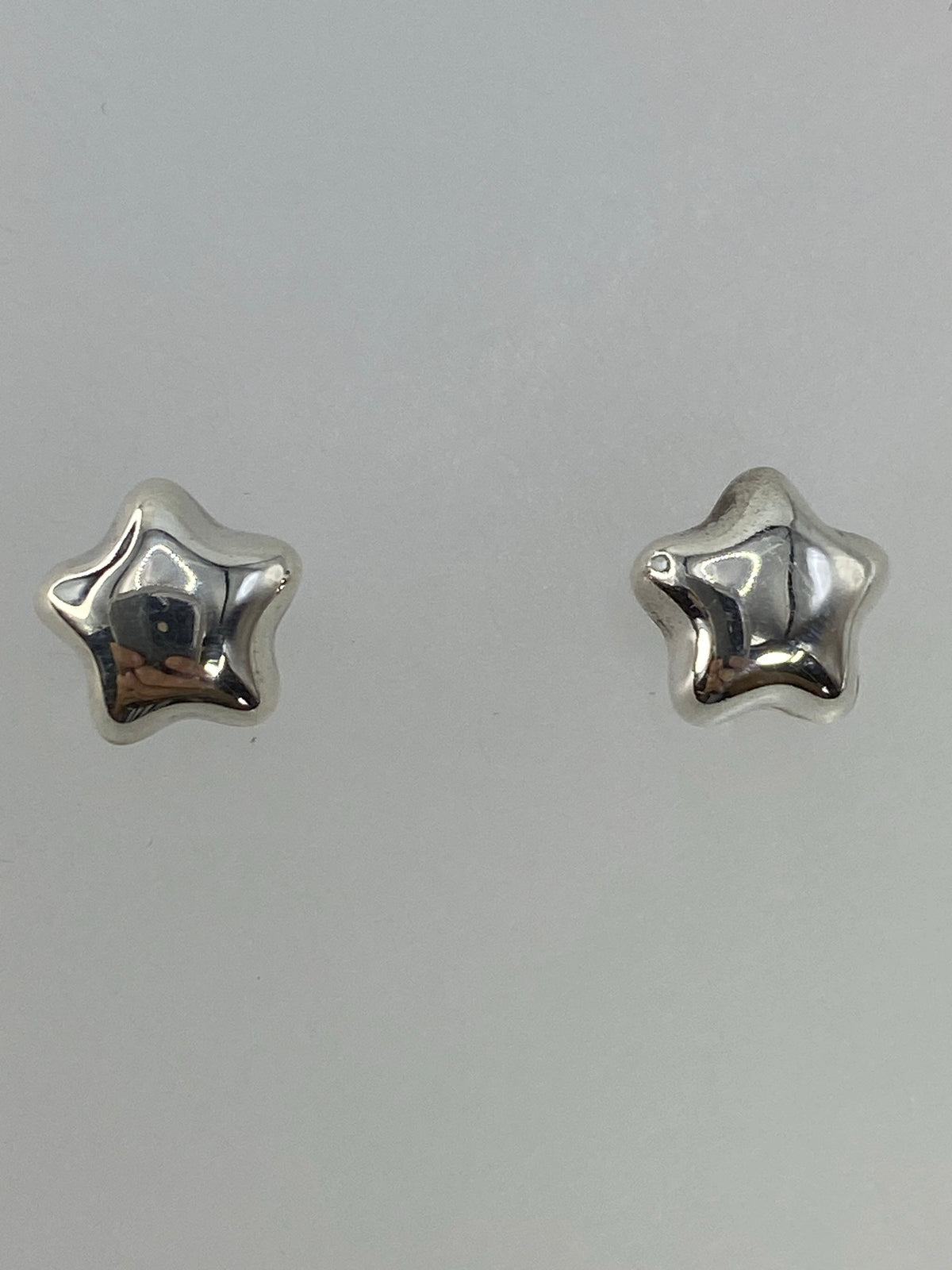 Detalle del cierre de poste de plata en arete cartoneado