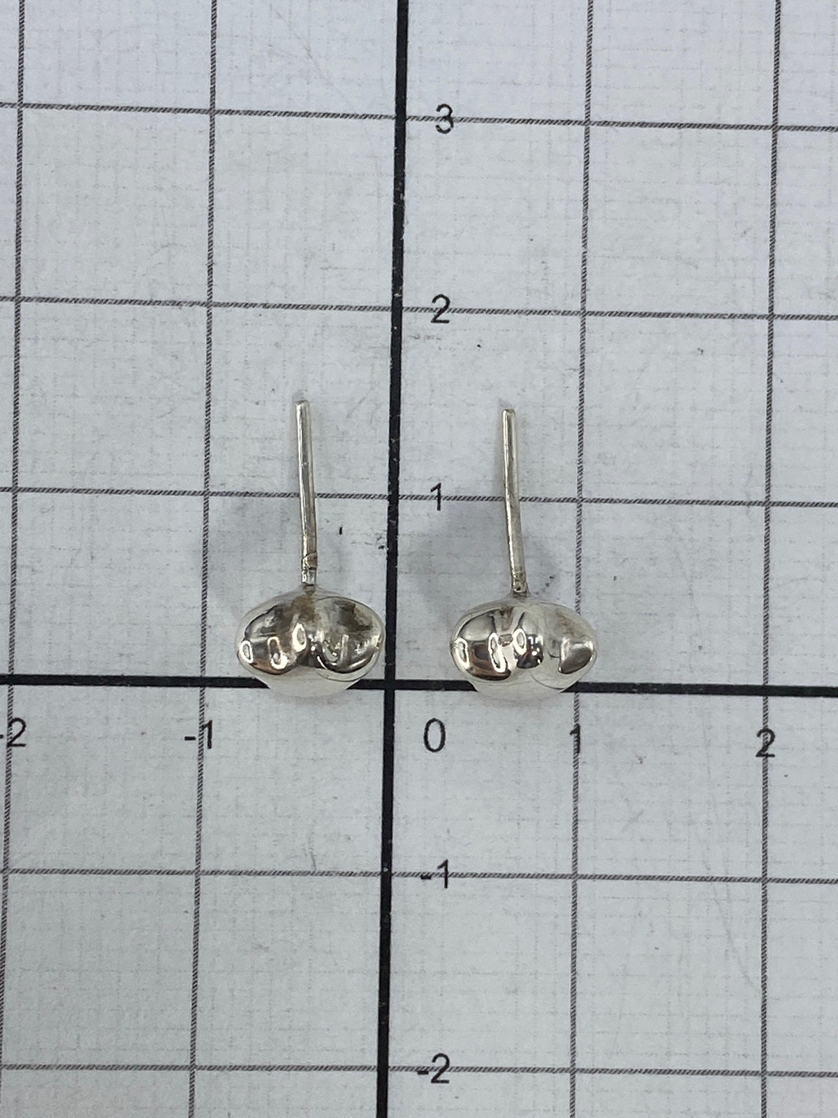 Aretes de plata 925 cartoneado con brillo pulido, sobre fondo gris