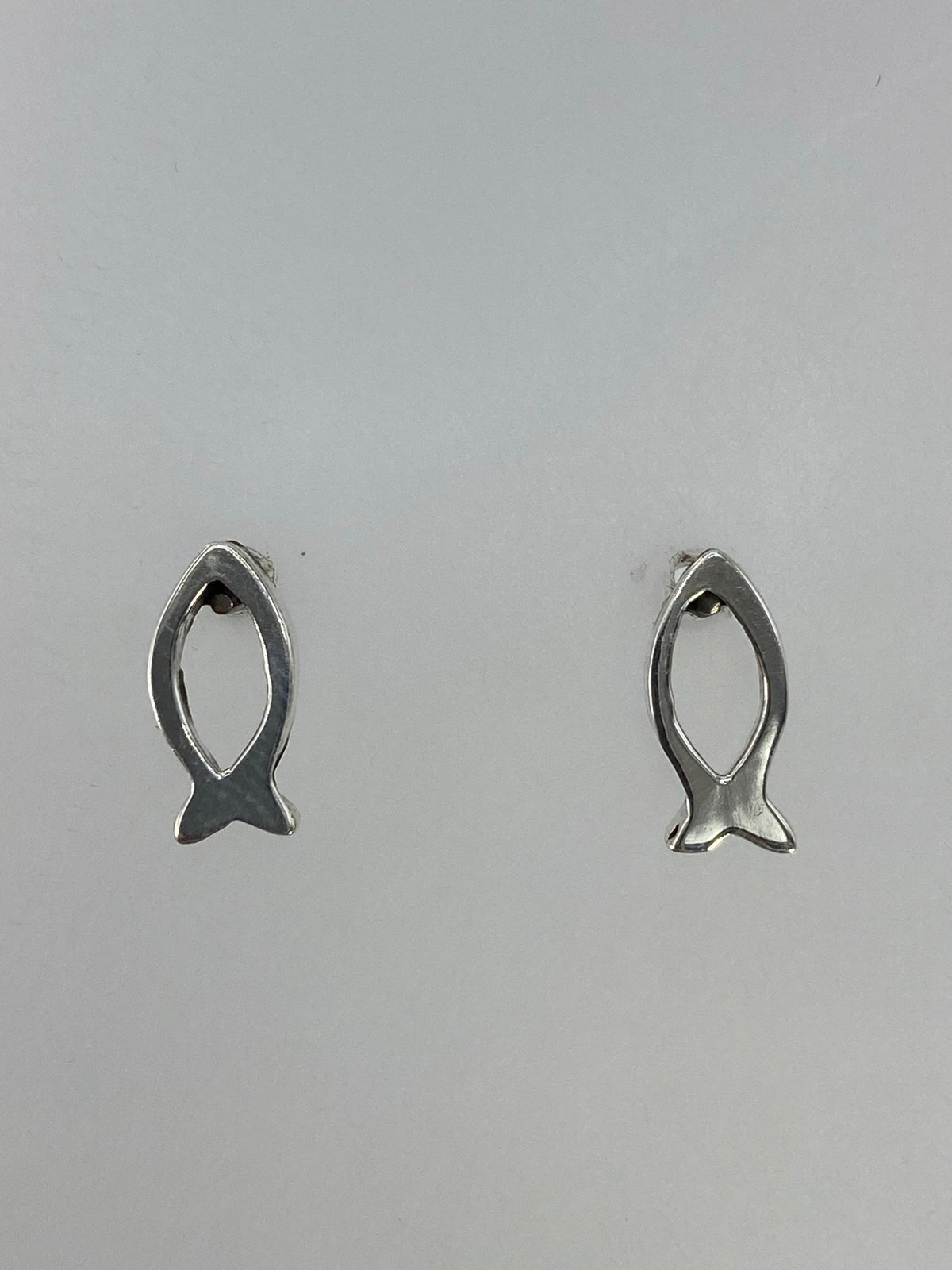 Par de aretes de plata 925 en forma de pez, técnica cartoneado, sobre fondo gris