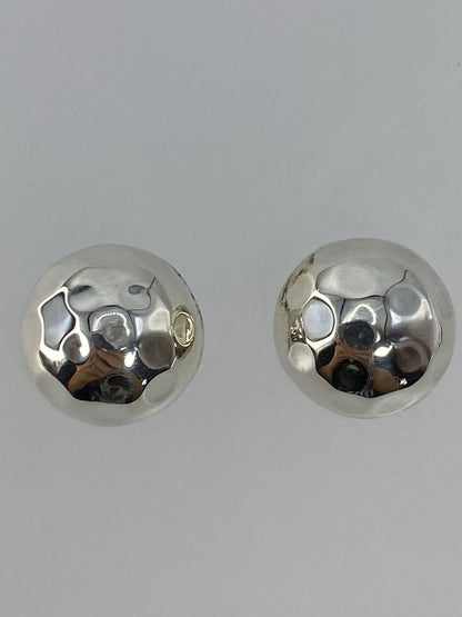 Par de aretes sobre escala mostrando el peso de 1.1 g