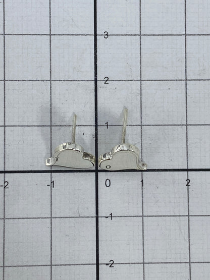 Aretes sobre balanza mostrando su peso ligero de 0.9 g