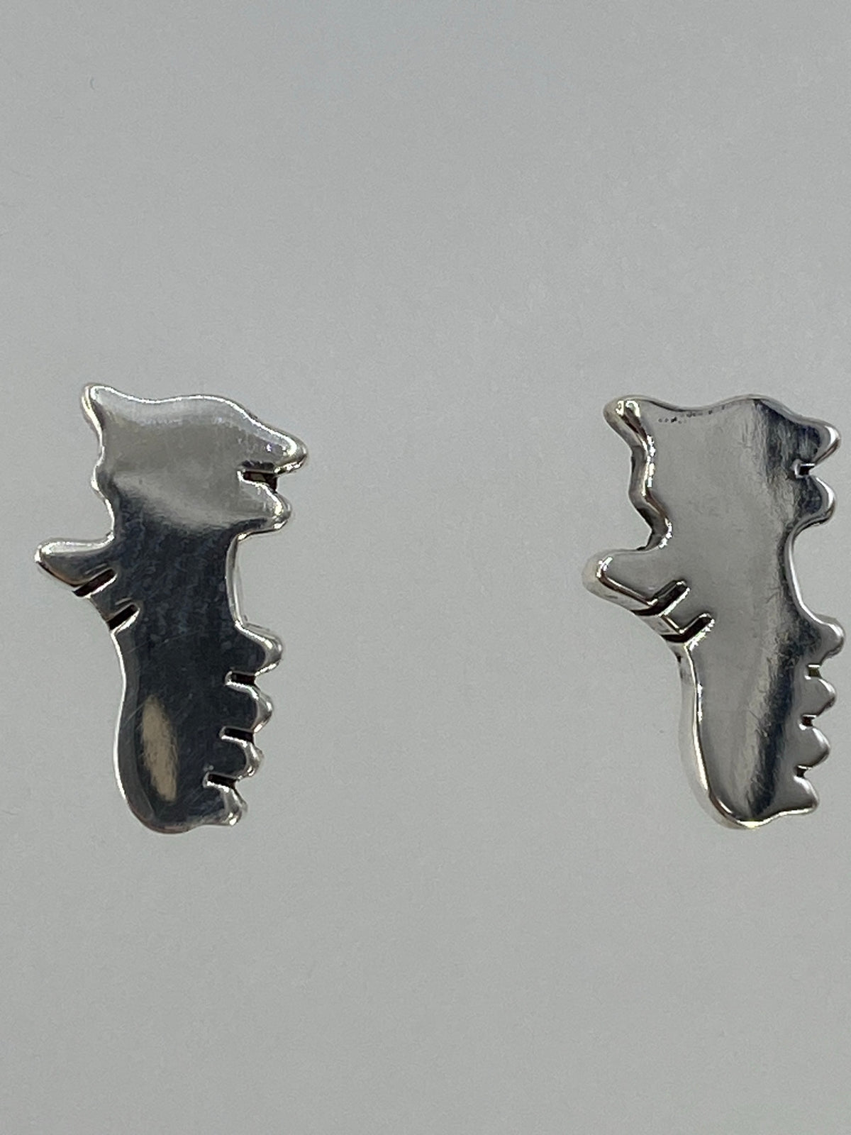 Aretes sobre regla métrica mostrando tamaño real de 1.2 cm