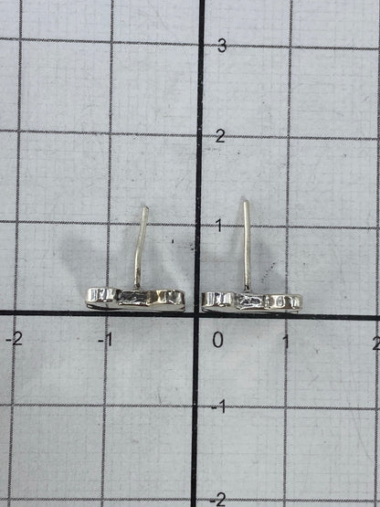 Aretes pequeños de plata 925 sobre fondo blanco mostrando su ligereza