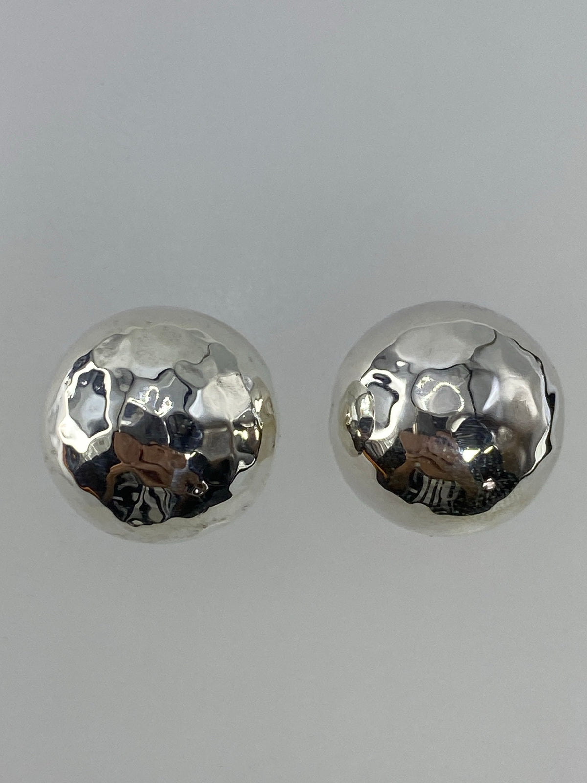 Detalle del acabado pulido de los aretes de cartoneado de plata