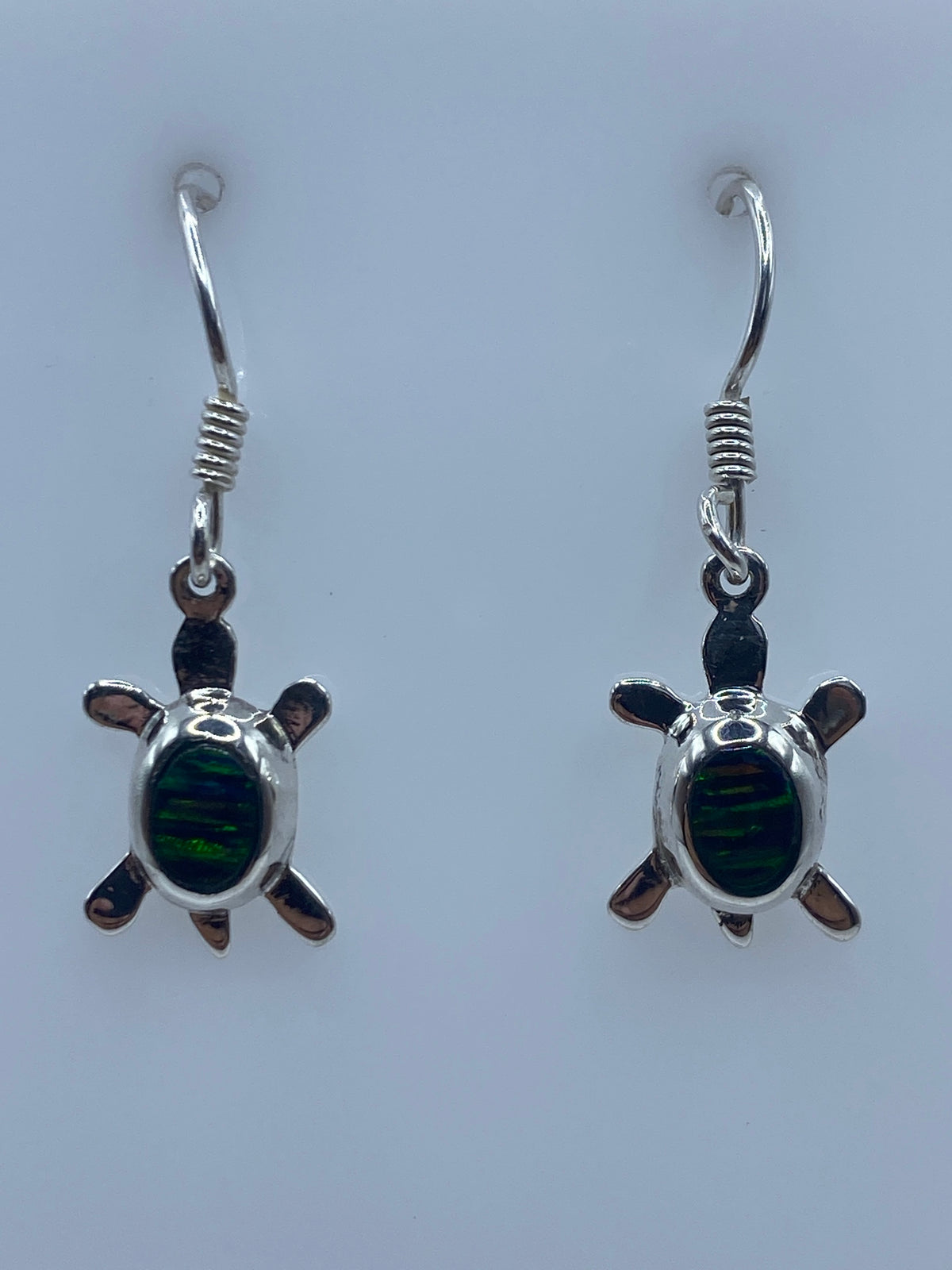 Par de aretes de plata con forma de tortuga y ópalo de fuego en los oídos