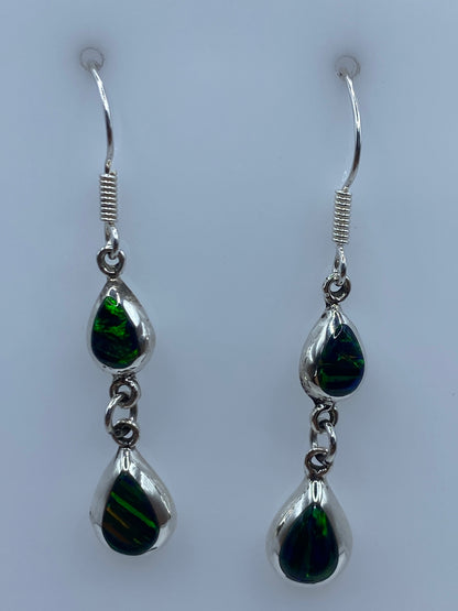 Detalle del ópalo de fuego verde engastado en plata, mostrando reflejos luminosos
