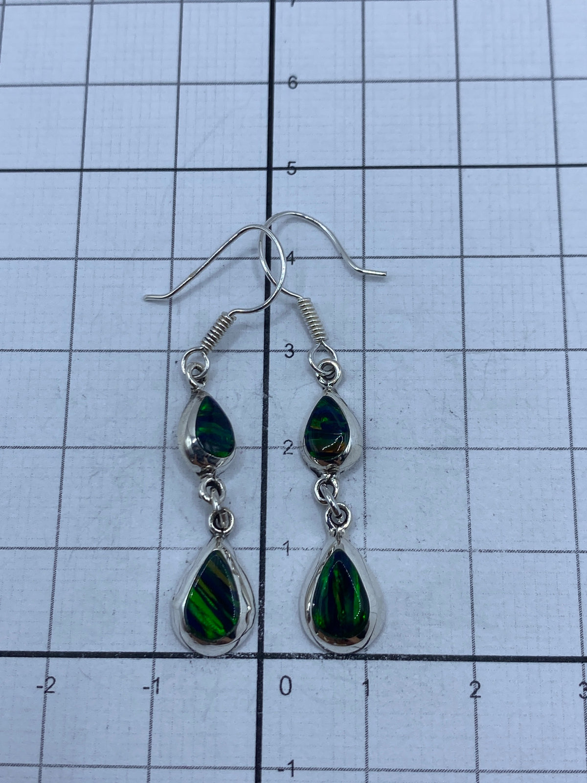 Reverso de los aretes con marca del Quinto 925, sobre fondo gris