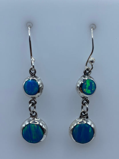 Par de aretes de plata con ópalo de fuego azul cielo colgando hacia adelante