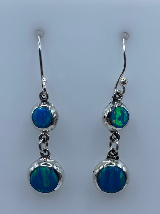 Par de aretes de plata con ópalo de fuego azul cielo colgando hacia adelante