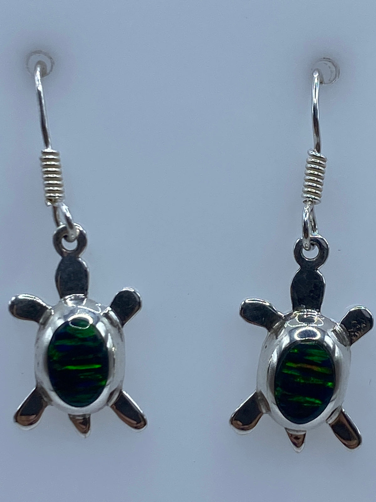 Aretes sobre regla de centimetros mostrando largo de 2.8 cm