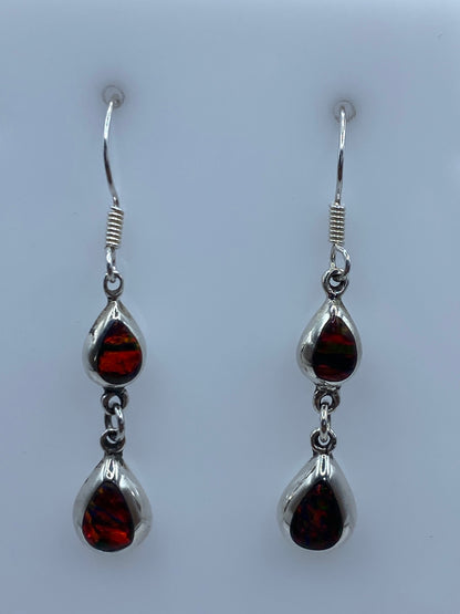 Par de aretes mostrando el opalo de fuego con reflejos rojos y anaranjados