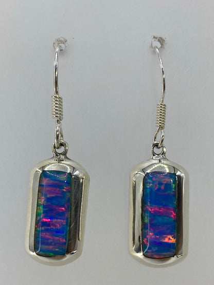 Par de aretes de plata con ópalo de fuego multicolor — rojo, naranja, azul y verde en juego de luz