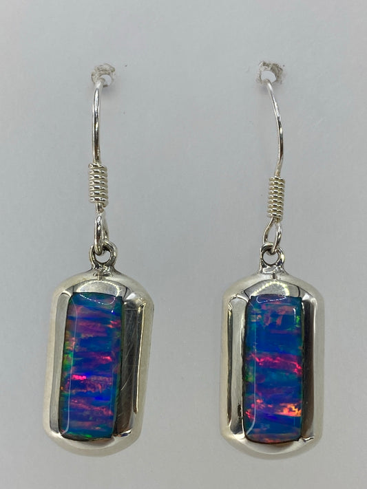 Par de aretes de plata con ópalo de fuego multicolor — rojo, naranja, azul y verde en juego de luz