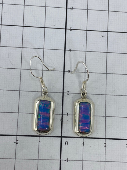 Aretes sobre regla de medición mostrando largo de 3 cm