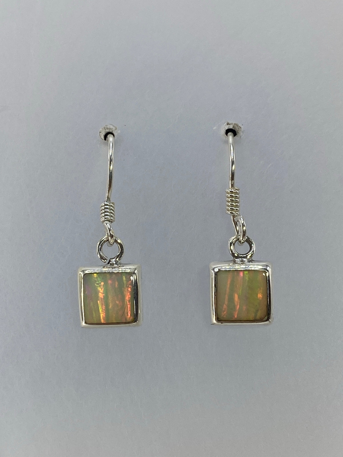 Aretes cuadrados de 2 cm con opalo de fuego engastado a mano, detalle del color