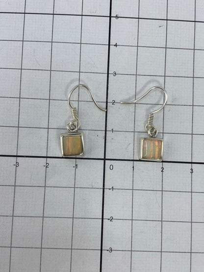 Aretes de opalo de fuego sobre fondo neutro, vista de frente del par